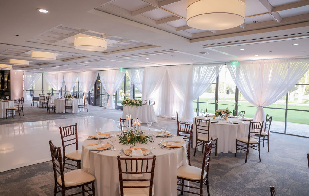 ballroom set up for a wedding with ballroom window draping and white dance floor